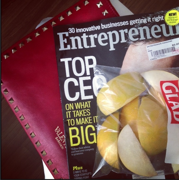 Valentino red studded clutch, Entrepreneur magazine and fruit.